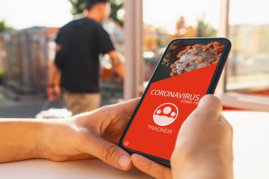 coronavirus tracking app on a mobile smartphone. Close up of woman tracking crowd of people in a smartphone screen application. Hand holding smart device. Mockup website. covid-19 corona virus tracker