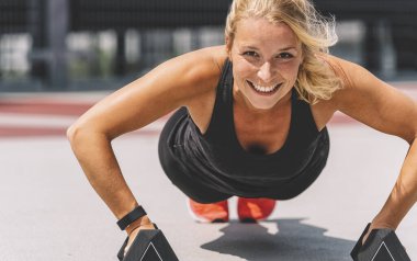 Çapraz eğitim. Dambıllarla egzersiz yapan genç bir kadın.