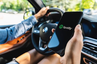 BERLİN, GERMANY HAZİRAN 2019: iPhone X 'ler açan bir kadın bir arabada uygulama açıyor, Spotify yasal müzik sunan bir müzik servisidir.