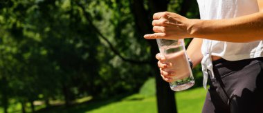Kadın koşucu elinde bir şişe su tutuyor. Su içme kavramı. Bireysel metnin için kopyalama alanı. pankart boyutu
