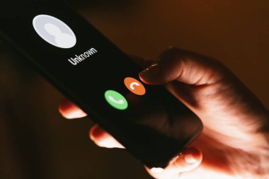 Akıllı telefon ve bilinmeyen bir telefon görüşmesi ile kadınların ellerini kapat. Sahtekarlık ya da dolandırıcılık.