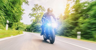 Orman yolunda motosiklet sürerken. Motosiklet turunda boş bir yolda araba kullanırken eğleniyorum.