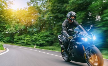 Orman yolunda motosiklet sürerken. Motosiklet turunda boş bir yolda araba sürerken eğleniyorum. bireysel metniniz için kopyalama alanı.