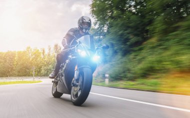 Orman yolunda motosikletli. Motosiklet turunda boş bir yolda araba sürerken eğleniyorum. bireysel metniniz için kopyalama alanı.