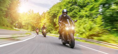 Orman yolunda motosikletli. Motosiklet turunda boş bir yolda araba sürerken eğleniyorum. bireysel metniniz için kopyalama alanı.