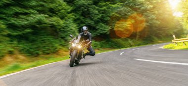 Orman yolunda motosiklet sürerken. Motosiklet turunda boş bir yolda araba sürerken eğleniyorum. bireysel metniniz için kopyalama alanı. 