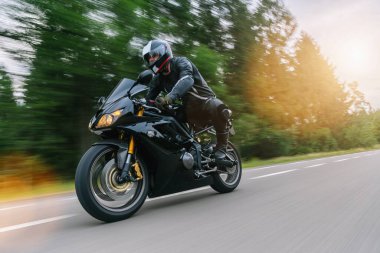 Orman yolunda motosiklet sürmek. Motosiklet gezisinde boş yolda araba kullanmak. bireysel metniniz için kopyalama alanı.