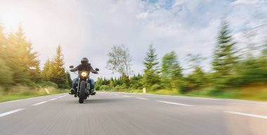 Motosikletli helikopter yolda. Motosiklet turunda boş bir yolda araba sürerken eğleniyorum. bireysel metniniz için kopyalama alanı.