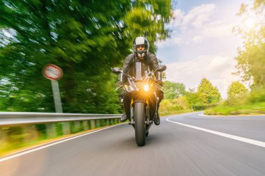 Trafik levhası olan bir motosiklet. Motosiklet turunda boş yolda araba kullanmak.
