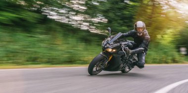 Orman yolunda virajlı bir şekilde motosiklet sürmek. Motosiklet gezisinde boş yolda araba kullanmak. bireysel metniniz için kopyalama alanı.