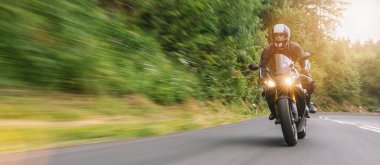 Orman yolunda motosiklet sürmek. Motosiklet turunda boş yolda araba kullanmak. bireysel metniniz için kopyalama alanı.
