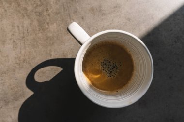 Gri arka planda bir fincan kahve, üst manzara.