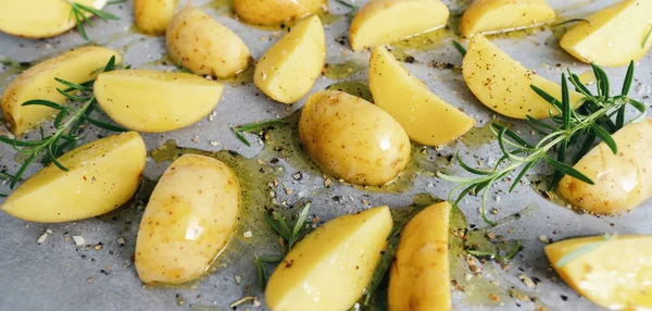 raw potato wedges with oil and pepper on baking tray