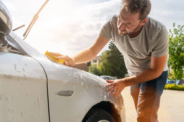 スポンジで車を洗う男労働者 — ストック写真