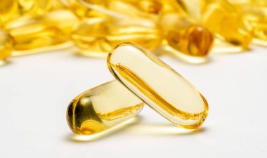 İki kapsül Omega 3 ve bulanık arka planda bir sürü başka kapsül. Sağlık hizmetleri konsepti