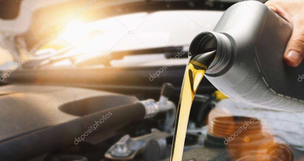 Pouring oil to car engine, close up