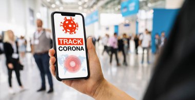 coronavirus tracker app on a mobile smartphone. Close up of woman tracking crowd of people in a smartphone screen application. Hand holding smart device. Mockup website. covid-19 corona virus tracker