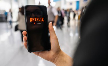 Berlin, Almanya Ocak 2020: Apple iPhone 'da Netflix uygulaması. Genç kadın film kütüphanesine göz atıyor. Ne izleyecekmiş?.