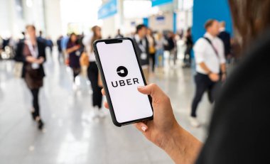 BERLİN, ALMANY 2020: Uber sürücüsü uygulaması üzerinden aramak için şehirde akıllı telefon tutan Uber müşteri. Uber, internet üzerinden ulaşım hizmeti sunan bir Amerikan şirketidir. İllüstrasyon Editörü.