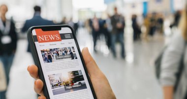 Cep telefonuyla internetten haberler. Akıllı telefon ekran uygulamasında haber ya da makale okuyan iş kadınlarını kapatın. El ele tutuşan akıllı cihaz. Model web sitesi. Gazete ve internet portalı.