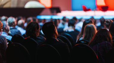 Speaker on the stage with Rear view of Audience in the conference hall or seminar meeting, business and education concept clipart