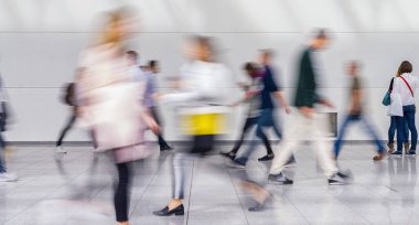 İş dünyasından isimsiz bir kalabalık bir ticaret fuarında koridora çıkıyor.