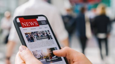 Bir cep telefonundan internet haberleri. Akıllı telefon ekran uygulamasında haber ya da makale okuyan iş kadınlarını kapatın. El ele tutuşan akıllı cihaz. Model web sitesi. Gazete ve internet portalı.