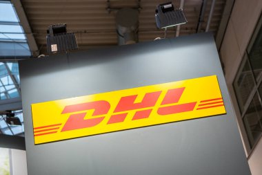 COLOGNE, ALMANE Eylül, 2019: DHL logosu bir ticaret fuarı standında. DHL, Alman lojistik şirketinin bir bölümüdür..