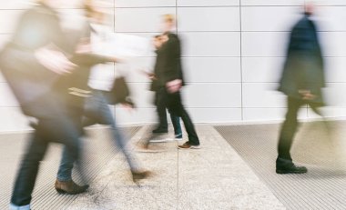 Anonim insanlardan oluşan kalabalık modern bir salonda yürüyor.