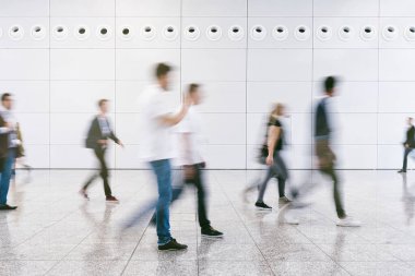 Anonim insanlardan oluşan kalabalık modern bir salonda yürüyor.