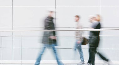 Bulanık insanlar Fait Hall 'da bir koridorda yürüyorlar.