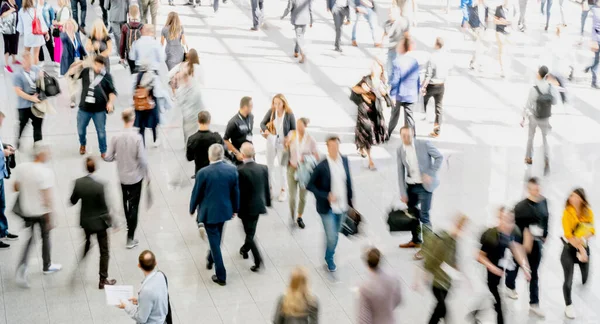 Anonymous blurred crowd on the go at a business trade fare