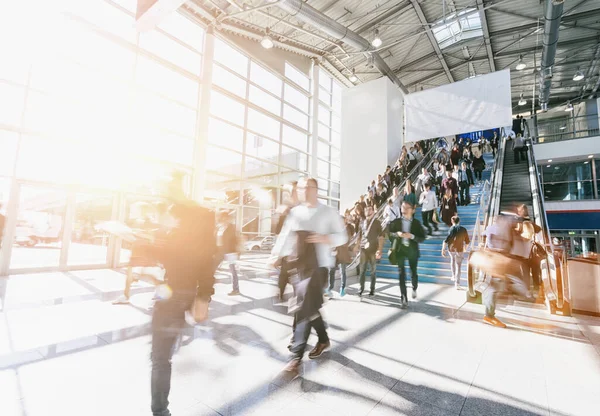 crowd of blurred business people at a trade show, with copy space banner