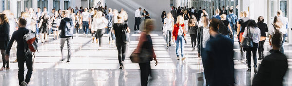 large crowd of anonymous blurred people at a trade fair
