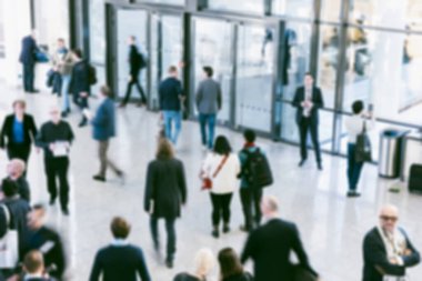 Bir ticaret fuarında odakları dağılmış insanlardan oluşan bulanık bir kalabalık