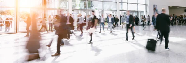 crowd of people walking in a hall