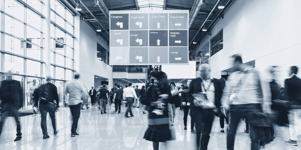 Anonymous blurred people walking in a hall of a Exhibition