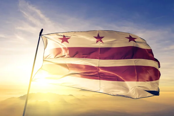 Washington DC of United States flag textile cloth fabric waving on the top sunrise mist fog