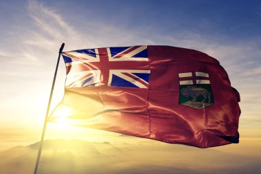 Manitoba Eyaleti Kanada bayrağı tekstil kumaş üst gündoğumu sis sis üzerinde sallayarak