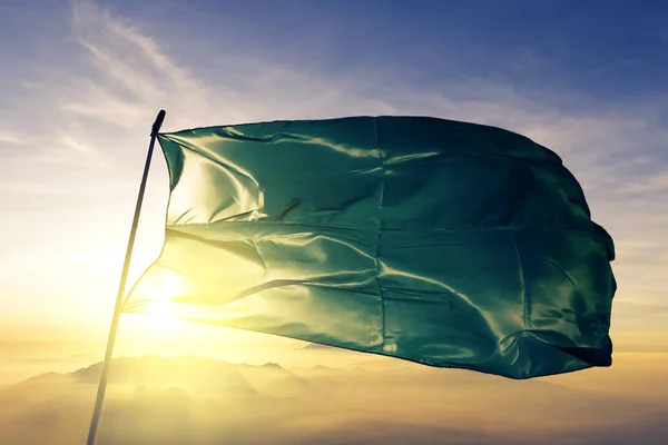 Green flag Beni State Department of Bolivia flag textile cloth fabric waving on the top sunrise mist fog