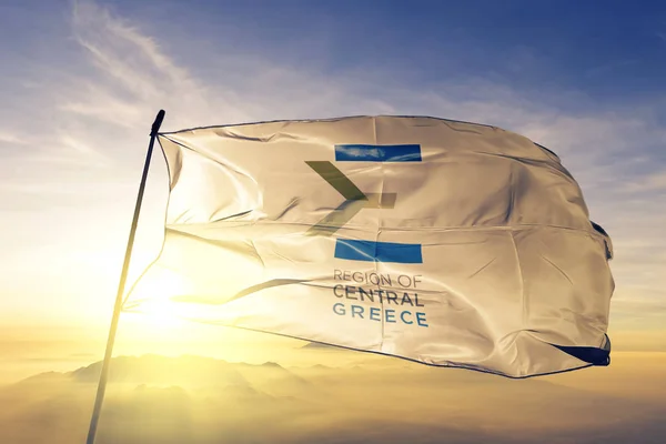 Central Greece region logo of Greece flag textile cloth fabric waving on the top sunrise mist fog