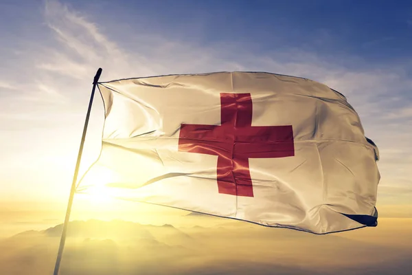Ερυθρού Σταυρού Ύφασμα Ύφασμα Σημαία Κυματίζει Στην Κορυφή Sunrise Ομίχλη — Φωτογραφία Αρχείου