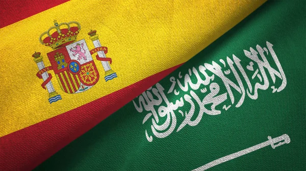 Spain and Saudi Arabia flags textile cloth, fabric texture. Text on saudi arabian flag means - There is no god but God, Muhammad is the Messenger of God