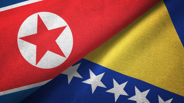 Corea del Norte y Bosnia y Herzegovina dos banderas tela textil, textura de la tela — Foto de Stock