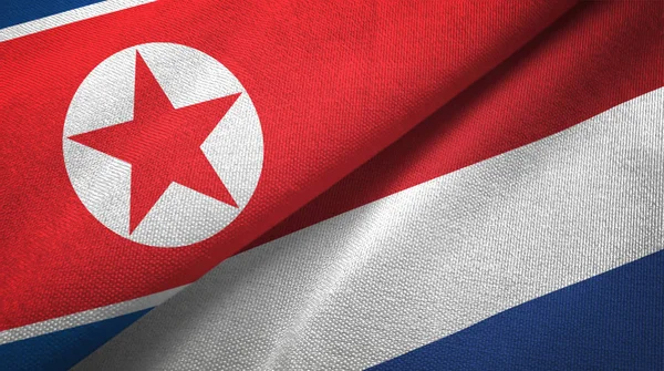 North Korea and Netherlands two flags textile cloth, fabric texture — Stock Photo, Image