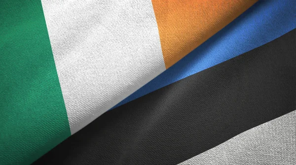 Irlanda y Estonia dos banderas tela textil, textura de la tela —  Fotos de Stock