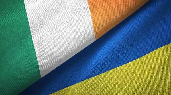 Irlandia i Ukraina dwie flagi tkanina tekstylna, tekstura tkaniny — Zdjęcie stockowe