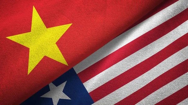 Vietnã e Libéria duas bandeiras de pano têxtil, textura de tecido — Fotografia de Stock