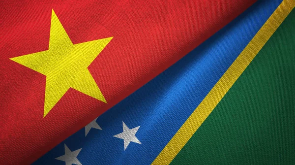 Vietnam y las Islas Salomón dos banderas tela textil, textura de la tela —  Fotos de Stock