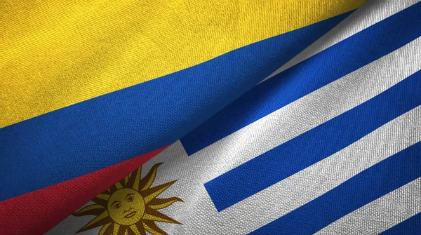 Colômbia e Uruguai duas bandeiras de pano têxtil, textura de tecido — Fotografia de Stock